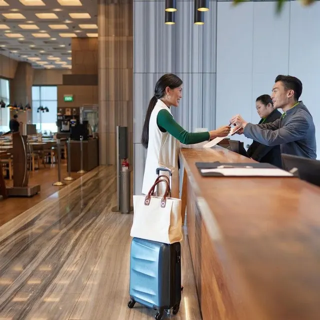 Recepción de un hotel con una clienta haciendo el check-in
